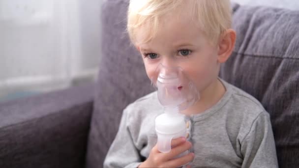 Primer plano retrato de lindo niño rubio rociando enfermedades respiratorias en casa — Vídeos de Stock