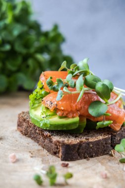 Somon, avokado ve mikroyeşillikli sağlıklı bir sandviç..