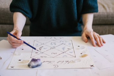 Kadın doğum çizelgesini kontrol ediyor. Güzel el çizimi astroloji arka planı.