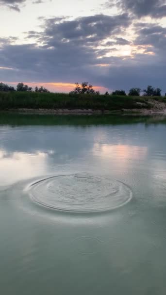 穏やかな水面での大きな神秘的な電球の波紋 遅い動き 湖の円 夕方の夕暮れ時の川の水 — ストック動画