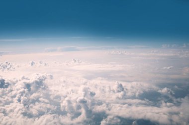 Mavi gökyüzü ve kümülüs bulutları uçaktan, seyahat modundan görünür