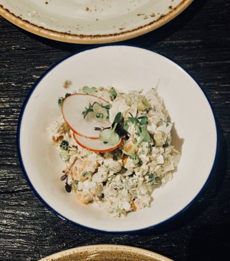 Yeni yıl olivier salatası ve restoran masasında turp.