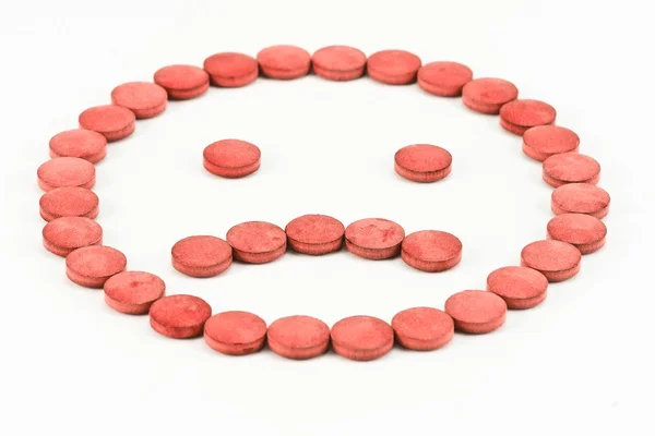 Red pills arranged in a sad smiley — Stock Photo, Image