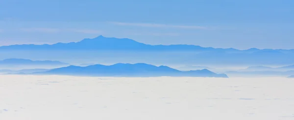 Гора возвышается над низкими облаками — стоковое фото