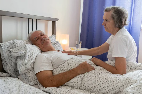 Yaşlı kadın, erkek, erkek, yatakta. Koca, hasta, yaşlı, hasta, aşkla ilgilenir..