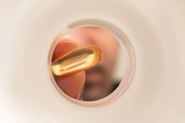 Genç erkek adam balık yağı kullanıyor. Omega 3 faydaları hafıza yaşamınızı geliştiriyor. Spor bağışıklık sistemi için sağlıklı.