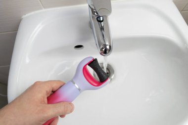 Ana konu odak dışı, elektro nasır sökücü, beyaz arka plan yakın plan eski cilt bakımı erkek el ele lavabosu