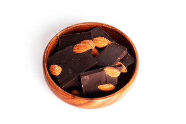 Kakaolu siyah çikolata ve beyaz arka planda izole edilmiş badem. Tahta kasede çikolata parçaları.