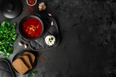 Koyu bir arka planda geleneksel Ukrayna Rus çorbası. Ekşi kremalı pancar çorbası. Maydanozlu pancar çorbası..