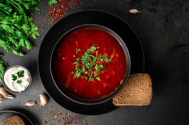 Koyu bir arka planda geleneksel Ukrayna Rus çorbası. Ekşi kremalı pancar çorbası. Maydanozlu pancar çorbası..