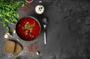 Koyu bir arka planda geleneksel Ukrayna Rus çorbası. Ekşi kremalı pancar çorbası. Maydanozlu pancar çorbası..