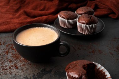 Koyu arkaplanda çikolatalı kekler olan kahve. Frenk üzümlü çikolatalı kek..