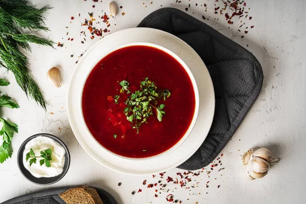 Hafif bir arka planda geleneksel Ukrayna Rus çorbası. Ekşi kremalı pancar çorbası. Maydanozlu pancar çorbası..