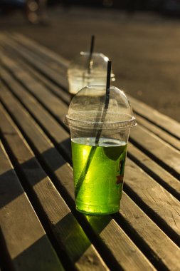 Şeffaf plastik bardakta parlak bir meşrubat.