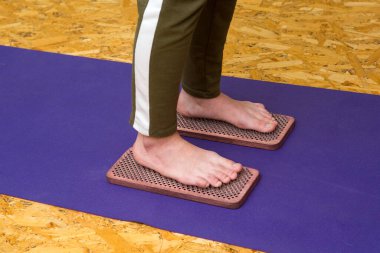 Çivilerin üzerinde durma alıştırması. Sadhu tahtasında keskin tırnakları olan bir yoga adamının yakın çekimi. Tahta sadhu tahtası ve sadhu için çiviler.