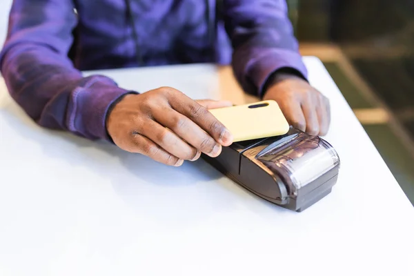 Чорний хлопець використовує смартфон для онлайн оплати через термінал — стокове фото