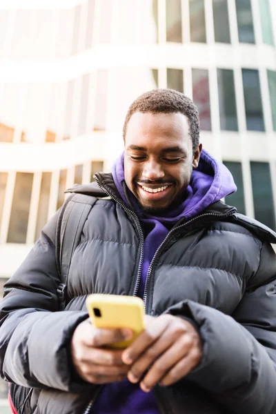 Веселого афроамериканця, який користується мобільним. — стокове фото
