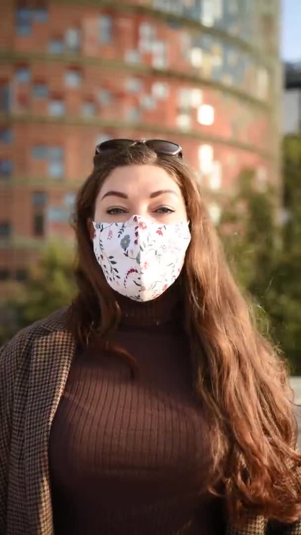 正の女性がマスクを脱ぐ。垂直ビデオ — ストック動画