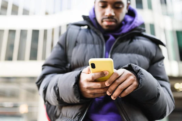 Чорний чоловік використовує смартфон на вулиці — стокове фото