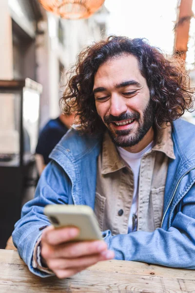 Hombre feliz usando teléfono inteligente en la cafetería de la calle — Foto de Stock