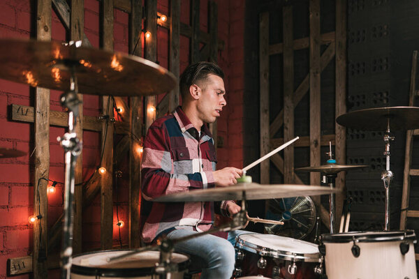 Male drummer playing drums at concert