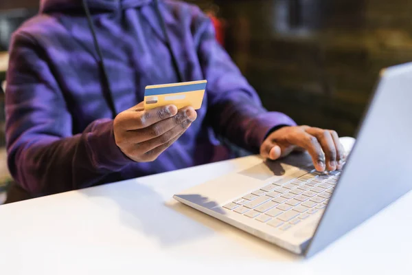 Siyah adam online alışverişi kredi kartıyla ödüyor.