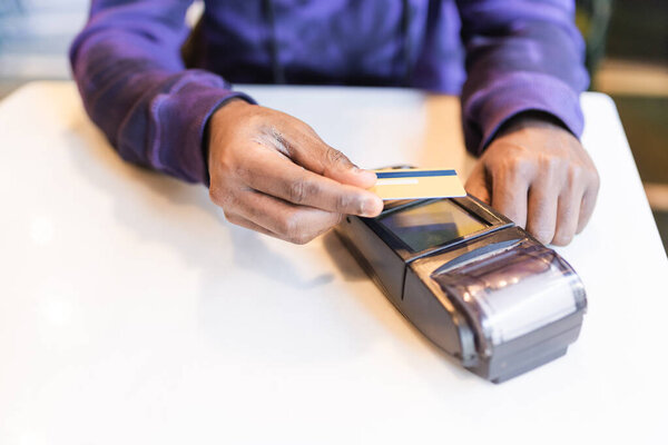 Black man paying with credit card through terminal