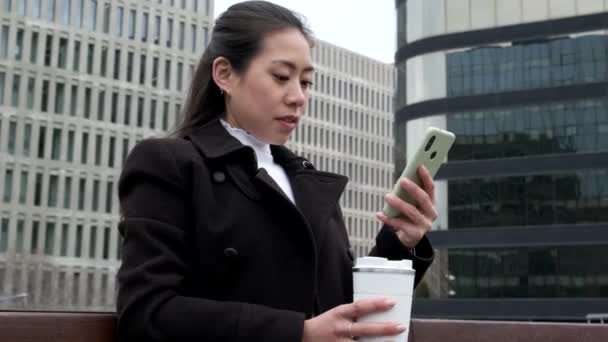 Chinese businesswoman browsing social media on cellphone — Stock Video