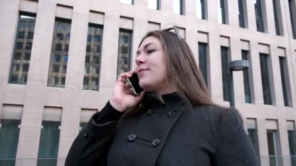 Woman talking on smartphone in city — Stock Video