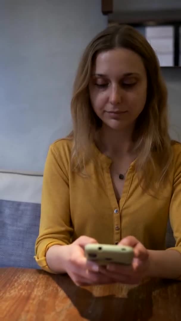 年轻美丽的女人在咖啡店里用手机发短信 — 图库视频影像