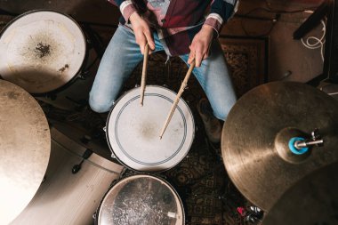 Canlı performans sırasında günlük giysiler içinde akustik davul çalan isimsiz erkek müzisyenin en iyi görüntüsü.