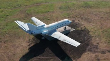 Havaalanındaki yeşil çimlerin üzerinde terk edilmiş bir uçak. Hava görünümü