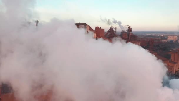Vista aérea. Tubos jogando fumaça no céu ao pôr do sol . — Vídeo de Stock