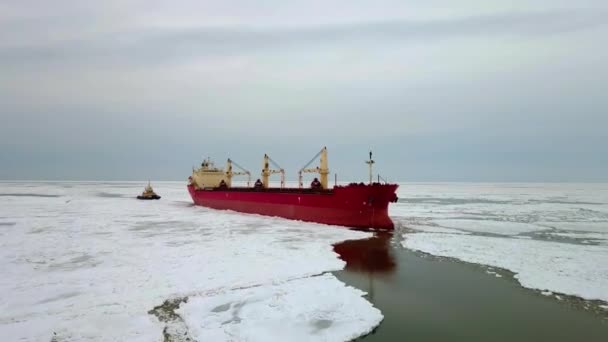 壮大な巨大な鋼製の砕氷船の上の空中は、船の弓で氷を破り、大きな海の氷の流れに浮かんでいます。凍結された海のチャンネル敷設のナビゲーションを維持する。自己推進特殊船舶紅船 — ストック動画