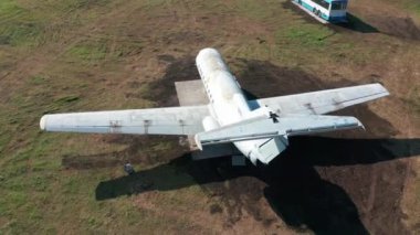 Havaalanındaki yeşil çimlerin üzerinde terk edilmiş bir uçak. Hava görünümü