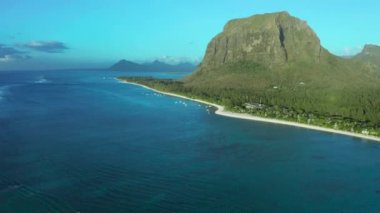 Hava görüntüsü. Gün batımında cennet gibi kayalık tropikal ada. Gün batımında okyanus dalgaları ve Le Morne Brabant. Mauritius.
