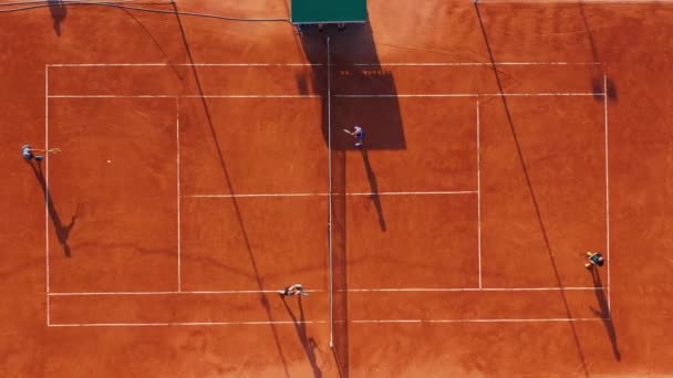 Jugadores de tenis en acción durante el partido en el estadio profesional. Vista aérea. Los jugadores están jugando tenis en la cancha naranja. — Vídeo de stock