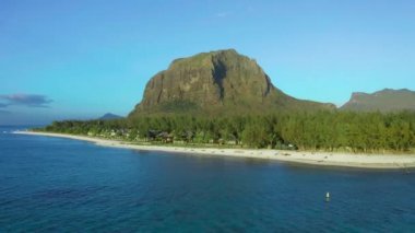 Hava görüntüsü. Gün batımında cennet gibi kayalık tropikal ada. Gün batımında okyanus dalgaları ve Le Morne Brabant. Mauritius.