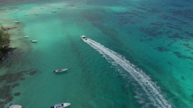 Mauritius 'taki okyanus manzarası. Turkuaz su, kumsallar, resifler ve bir ada. Bir wakeboard teknesinin etrafında uçmak