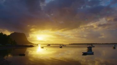 Okyanus boyunca gün batımının ışıltılı video görüntüleri. Dünyanın en iyi gün batımı. Adanın arka planında okyanus batımı