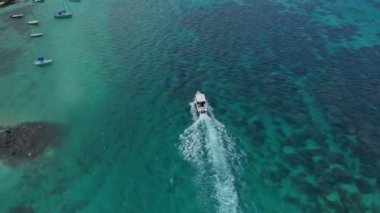 Mauritius 'taki okyanus manzarası. Turkuaz su, kumsallar, resifler ve bir ada. Bir wakeboard teknesinin etrafında uçmak