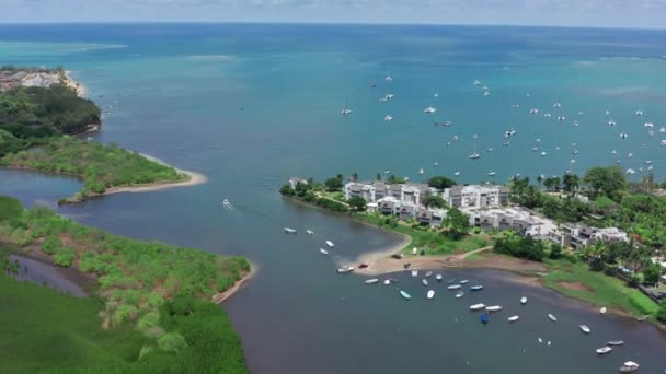 Bovenaanzicht vanuit de lucht van oceaanblauw transparant water en bewegend motorwit jacht, camera beweegt zich naar de kust met bos, palmbomen, zandstrand, Mauritius Island. Grande Riviere Noire, eiland Mauritius — Stockvideo