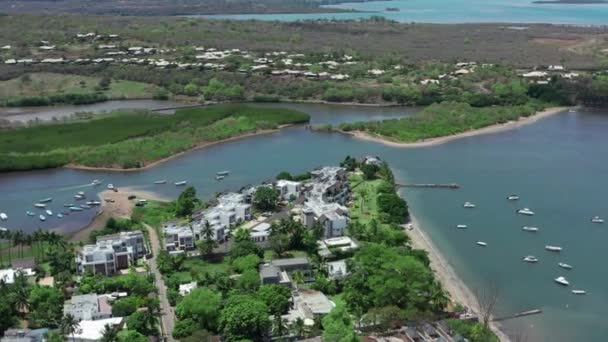 Bovenaanzicht vanuit de lucht van oceaanblauw transparant water en bewegend motorwit jacht, camera beweegt zich naar de kust met bos, palmbomen, zandstrand, Mauritius Island. Grande Riviere Noire, eiland Mauritius — Stockvideo