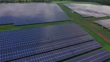 Yenilenebilir elektrik üretimi için güneş enerjisi panelleri olan yeşil alanın havadan görünüşü.