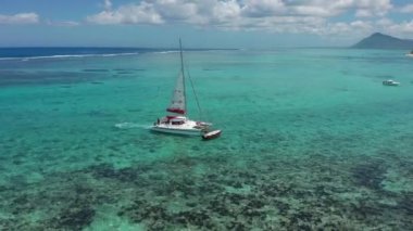 Mauritius adasının arka planında turkuaz su katamaranı var. İHA görüntüleri açık denizde yüzen katamaranların havadan görüntüsü..