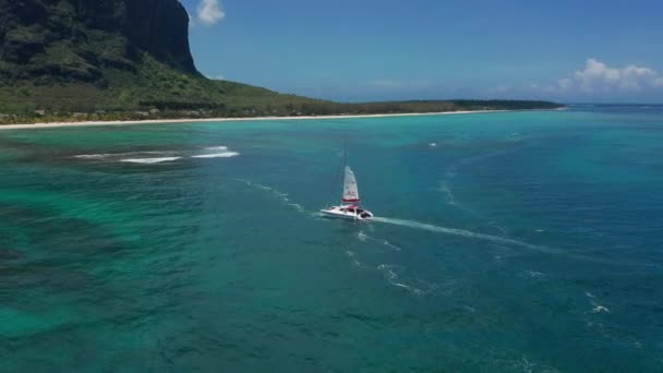 Katamarán v tyrkysové vodě na pozadí ráje ostrova Mauricius. Dron záběry antény pohled shora katamaránu plachtění na otevřeném moři. — Stock video