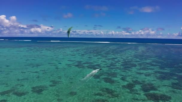 Flygfoto man kitesurfing i Indiska oceanen. Tropisk lagun med turkost vatten och vit sand. Vacker himmel, hav, strand, resort — Stockvideo