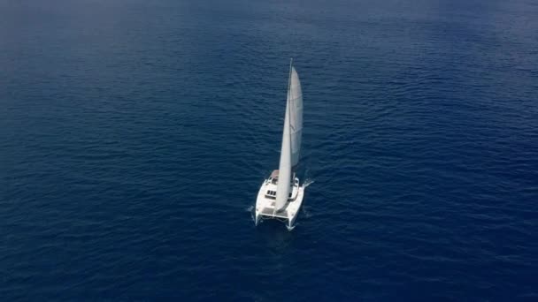Caméra suivre catamaran dans l'eau bleue de l'océan. Le secteur des voyages se remet de la pandémie de coronavirus. Vidéo de drone vue aérienne du haut vers le bas. — Video