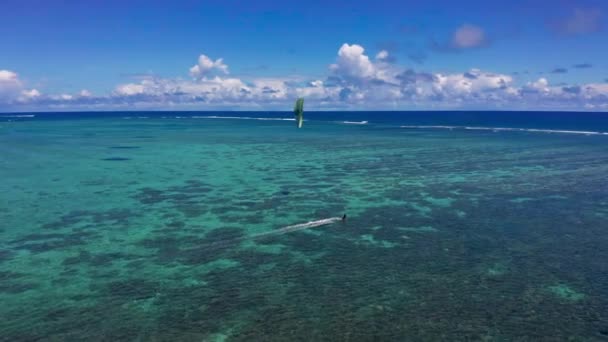 Antilles fond de plage. Plage tropicale ensoleillée. Vue aérienne jeune homme cerf-volant surf dans l'océan bleu tropical — Video