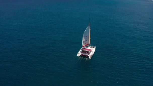 熱帯の海でカタマランを帆を開いてセーリングし、ドローンからの眺め。モーリシャス — ストック動画